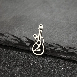 Macro shot of silver guitar pendant with E3 engraving on textured grey rock