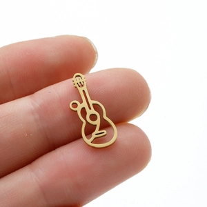 Golden hollow guitar pendant in stainless steel held between fingers for DIY jewelry