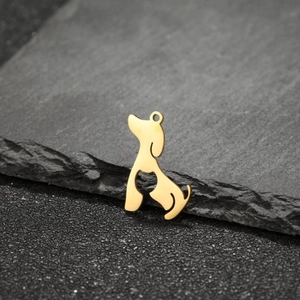 Close-up of golden stainless steel hollow Poodle dog pendant silhouette on dark stone