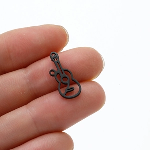 Miniature matte black guitar pendant in stainless steel shown on fingertip for size scale