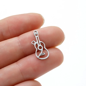 Polished silver guitar pendant in stainless steel held on finger for scale