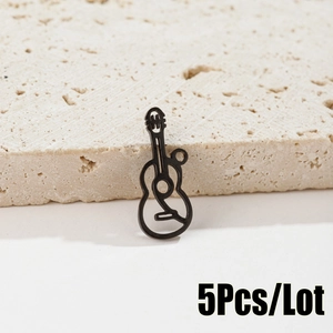Detailed view of 5pcs black cutout guitar charms on a beige stone background