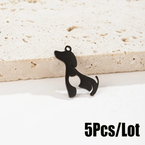 Detailed view of five matte black puppy pendants with hollow heart on beige stone