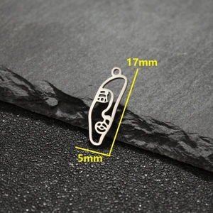 Minimalist silver abstract face pendant with dimensions 17mm by 5mm on rock background