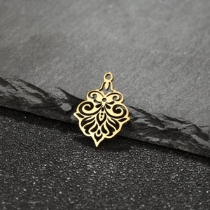 Macro view of gold hollow-out floral pendant with baroque patterns on stone background