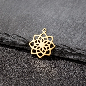 Polished golden stainless steel mandala flower pendant on dark textured background