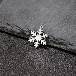 Detailed view of a silver snowflake pendant with a polished stainless steel finish