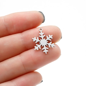 Detailed close-up of a silver snowflake pendant charm in hand showing its 12mm small size