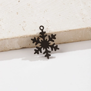 Macro shot of matte black snowflake pendant with geometric cuts on textured stone