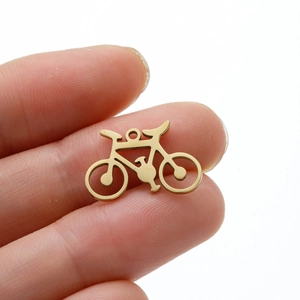Macro shot of 18k gold plated bicycle pendant showing small size held between fingers