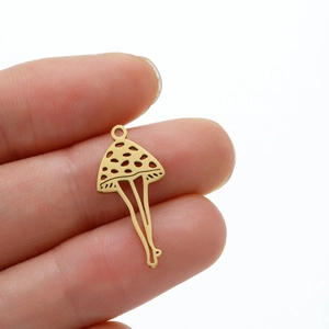 Macro shot of 18k gold plated stainless steel mushroom charm with legs for DIY jewelry