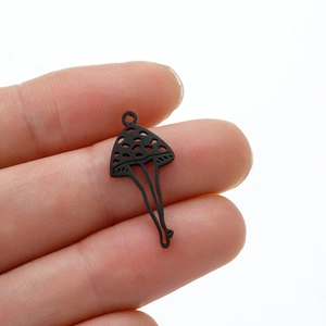 Detailed close-up of a black matte mushroom pendant with hollowed polka dot design
