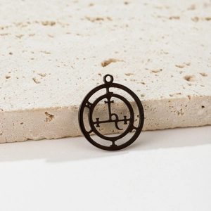Vue détaillée d'un pendentif sigil en acier inoxydable noir sur pierre