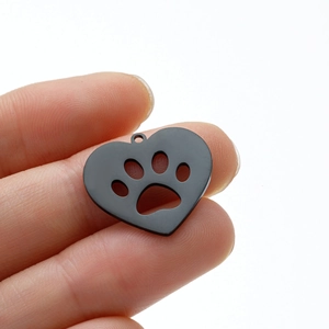 Gros plan d'un pendentif cœur noir mat avec empreinte de patte évidée