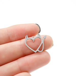 Macro shot of silver devil heart pendant in stainless steel with horn and tail detail