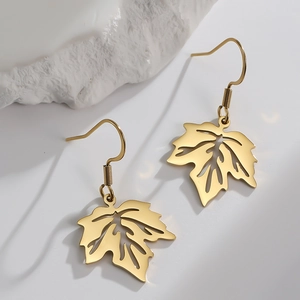 Elegant gold maple leaf drop earrings with hollow veins on minimalist stone background