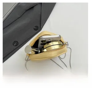 Interior view showing the capacity of this yellow mini crossbody bag with a silver chain