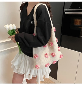 Détail du sac à bandoulière en maille crème avec motifs floraux 3D et large sangle