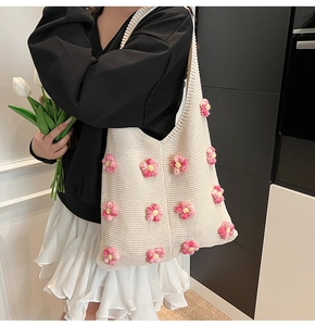 Détail d'un sac cabas en tricot crème avec fleurs roses en crochet et maille fine