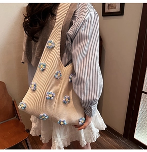 Gros plan du sac en maille avec des décorations florales 3D bleues et violettes faites main