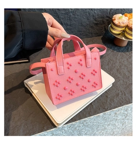 Détail du sac à main en cuir rose avec clous 3D et poignée supérieure élégante