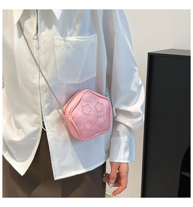 Close-up of pink star-shaped crossbody bag with silver chain strap worn by a model