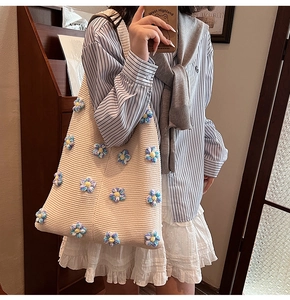 Détail du sac cabas en tricot beige orné de fleurs au crochet 3D colorées et douces