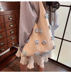 Détail rapproché des fleurs en tricot 3D sur le sac à bandoulière blanc crème