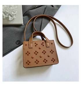 Détail du sac bandoulière en cuir grainé marron avec motifs de rivets rétro élégants