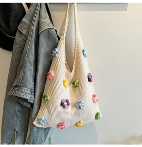 Détail d'un sac bandoulière en tricot crème avec fleurs 3D au crochet et texture douce