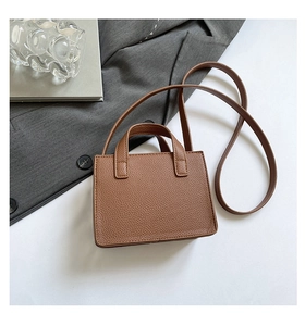 Vue de dessus du mini sac carré en cuir grainé caramel avec doubles poignées et bandoulière