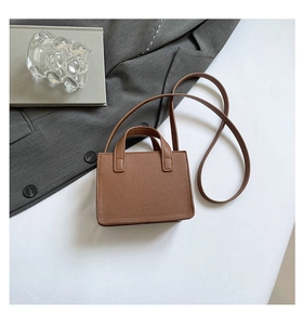 Vue détaillée du mini sac bandoulière marron caramel en cuir litchi avec deux poignées