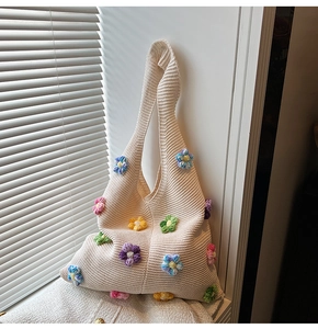 Gros plan sur les fleurs en tricot 3D et la texture du tissu d'un sac à bandoulière
