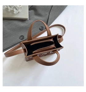 Détails du sac à main marron en cuir grainé avec rivets et compartiment zippé à l'intérieur