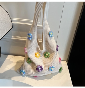 Détail du sac en tricot blanc avec fleurs au crochet 3D colorées et maille ajourée