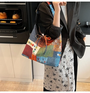 Detail of bohemian patchwork tote bag featuring vibrant patterns and a side brand tag