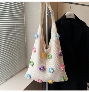 Détail du sac à bandoulière en maille crème avec fleurs colorées au crochet 3D