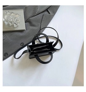 Détail du mini sac en cuir noir grainé avec deux compartiments zippés et une bandoulière
