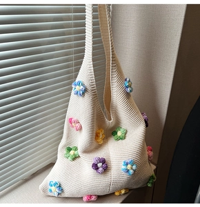 Détail du sac hobo en tricot crème avec des fleurs colorées en relief faites à la main
