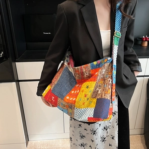 Detail view of colorful patchwork tote bag with adjustable shoulder strap on model