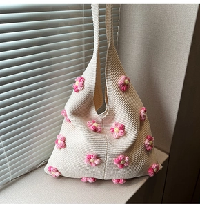 Gros plan du sac en tricot crème avec fleurs au crochet roses 3D et texture moelleuse
