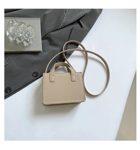 Vue détaillée d'un sac bandoulière beige en similicuir grainé avec double poignée