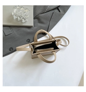 Vue de dessus du sac en cuir beige montrant le compartiment zippé interne et la sangle