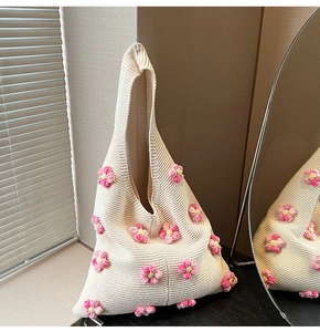 Détail du sac à bandoulière en tricot blanc avec fleurs au crochet roses et jaunes
