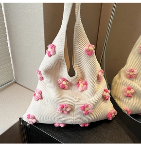 Gros plan sur le sac en tricot crème avec des détails de fleurs 3D faites à la main
