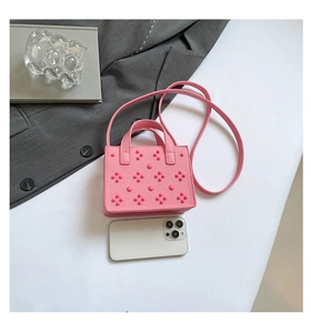 Détail du mini sac carré rose clouté avec texture litchi et bandoulière amovible