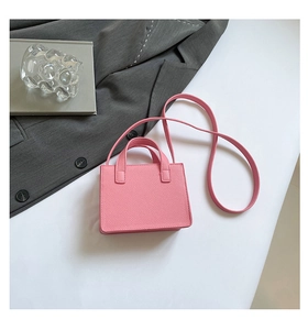 Détail d'un mini sac bandoulière rose vif avec texture cuir et rivets argentés chic