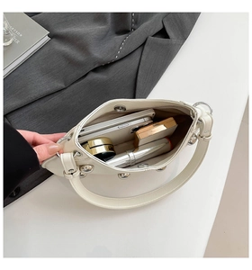 Vue de dessus du sac crème à rivets montrant l'espace pour téléphone et cosmétiques