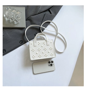 Petit sac blanc clouté en similicuir avec un smartphone pour comparer la taille réelle