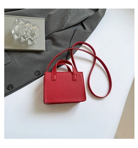 Vue détaillée de dessus d'un petit sac carré rouge avec texture litchi et bandoulière